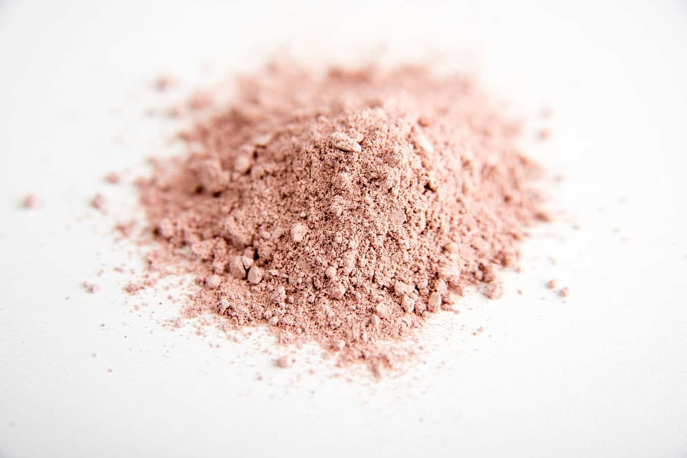 Precision-fermented lactoferrin powder in a clean white bowl on a neutral background